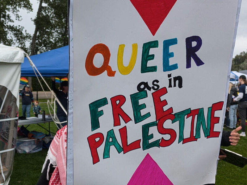 A protest sign reading "Queer as in Free Palestine"