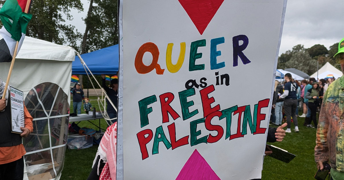 A protest sign reading "Queer as in Free Palestine"